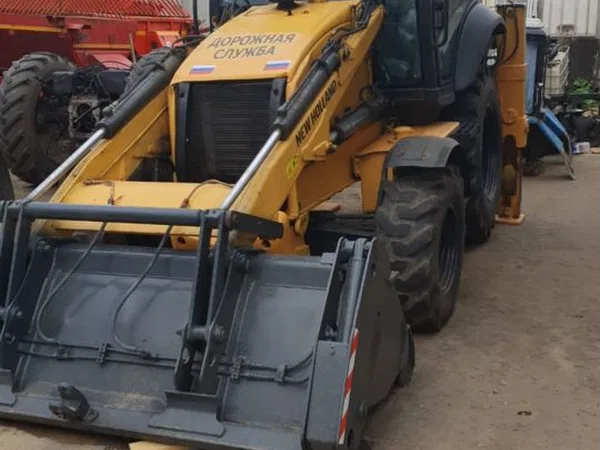 Экскаватор-погрузчик New Holland с гидромолотом
